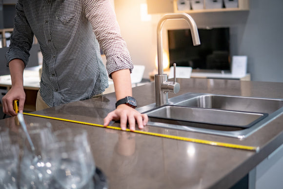 man-using-tape-measure-for-measuring-granite-countertops