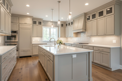 Transitional kitchen with frameless Shaker cabinets in Accessible Beige (SW 7036), white quartz countertops, polished nickel hardware, neutral tile backsplash, medium-tone wood floors, balanced warm lighting, refined and timeless design, no people, no logos.
